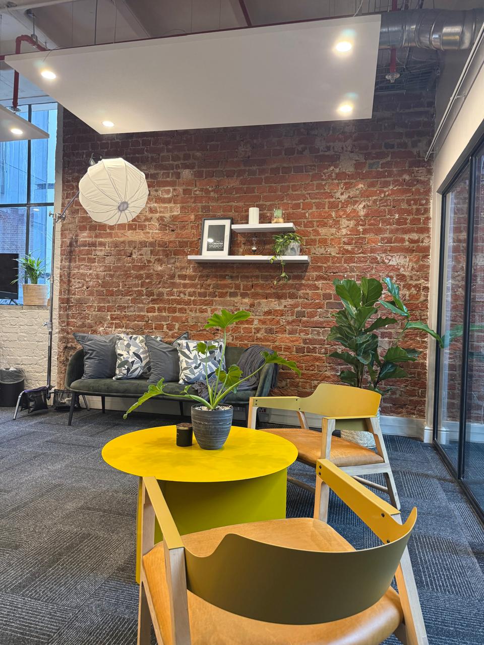 Create at Studio17 interior with brick wall, sofa and production lighting